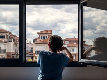 Un niño mira por la ventana