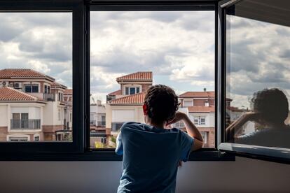 Un niño mira por la ventana
