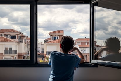 Un niño mira por la ventana