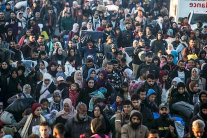 Desplazados palestinos caminan hacia sus viviendas 
 por la carretera Al Rashid en el centro de Gaza hacia el norte de la Franja.