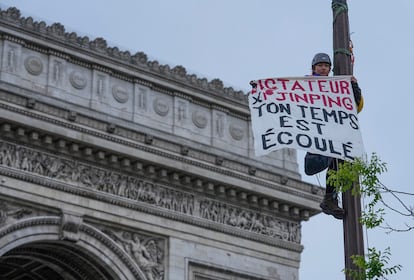 Un activista por el Tibet coloca un cartel este sábado en París que dice: "Dictador Xi Jinping, tu tiempo se agota".