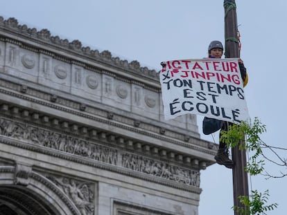 Un activista por el Tibet coloca un cartel este sábado en París que dice: "Dictador Xi Jinping, tu tiempo se agota".
