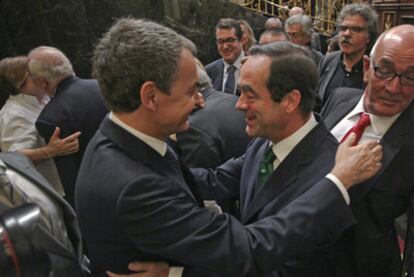 Zapatero y Bono se abrazan en presencia de otros diputados tras el último pleno de la legislatura en el Congreso.