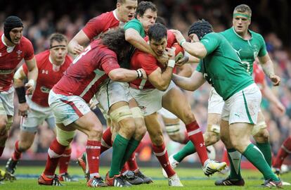 Mike Phillips de Gales defiende el balón, protegido por los jugadores de su equipo, ante Irlanda.