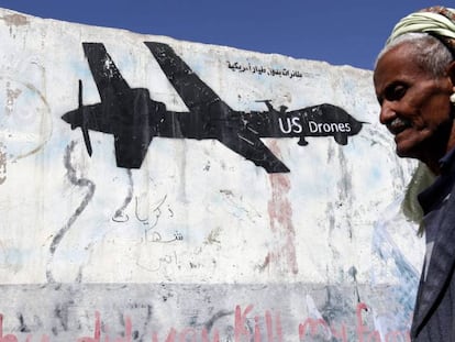 Un yemení pasa junto a una pared en Saná, capital de Yemén, en la que un grafiti protesta contra los ataque aéreos de EE UU.
