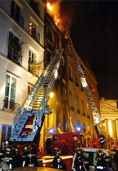 Los bomberos de París luchan contra las llamas durante la noche del lunes.