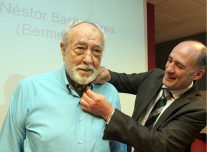 El vicerrector del campus de Vizcaya, Iñaki Goirizelaia, coloca a Basterretxea la insignia de plata