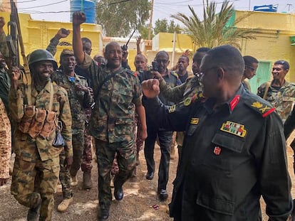 This picture released on the Sudanese Army's Facebook page on May 30, 2023, shows army chief Abdel Fattah al-Burhan cheering with soldiers as he visits some of their positions in Khartoum.