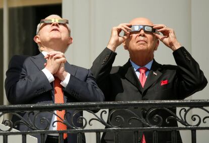 A la izquierda, el fiscal jefe (ministro de Justicia) de EE UU, Jeff Sessions, observa el eclipse de sol mientras cruza sus manos. Junto a él, el secretario de comercio, Wilbur Ross.