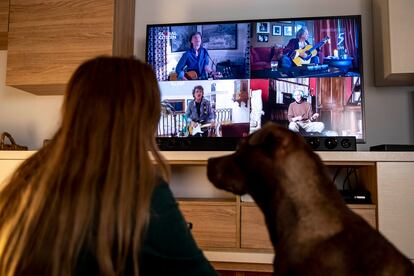 Una mujer viendo en su casa el pasado abril a los Rolling Stones en el concierto virtual 'One World: Together at Home', organizado por Lady Gaga.