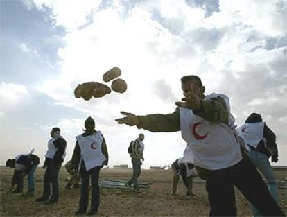 Voluntarios de la Media Luna Roja retiran piedras en el desierto jordano para construir un campo de refugiados.