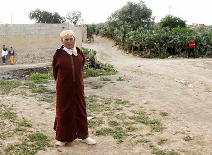 Un anciano posa ante la aldea marroquí de Chraga. A su derecha arranca el camino que marca la frontera entre Marruecos y Argelia y que parte en dos al pequeño pueblo.