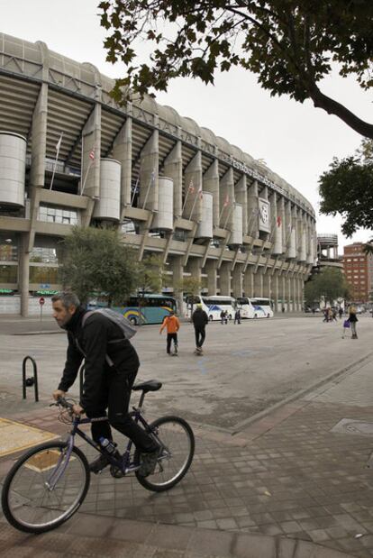 Un ciclista circula frente al Bernabéu, donde se levantará la nueva zona comercial.