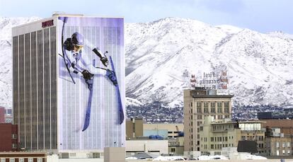 La imagen gigantesca de un esquiador aparece sobre la fachada de un edificio de oficinas del banco Key Bank, en Salt Lake City (EEUU) 2002. Al fondo, las montañas nevadas de Wasatch. Muchos edificios de la ciudad serían decorados con imágenes de esquí similares.