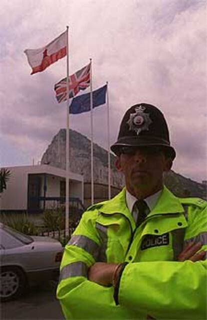 Un policía de Gibraltar, ante las banderas de la colonia.