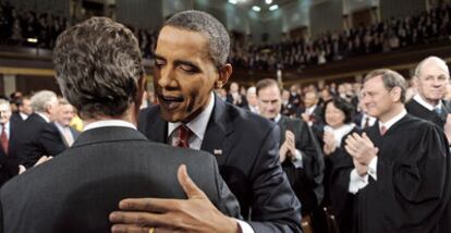 Barack Obama habla al oído al secretario del Tesoro Timothy Geithner al entrar en la cámara