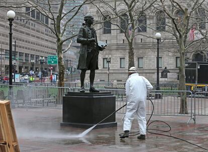 La escultura del pintor John Singleton Copley es lavada por un empleado de la ciudad este martes 23 de abril de 2013, mientras comienza la reapertura de la calle a los residentes y dueños de negocios pequeños, una semana después del doble atentado en el Maratón de Boston.