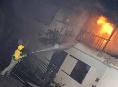 Un bombero apaga las llamas en una vivienda del municipio de Fuencaliente.
