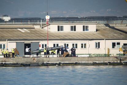 Con la ayuda de una grúa pluma portátil se procedió a retirarle el armamento. En la foto, militares y obreros asegurando para su carga un misil Tomahawk sacado del submarino nuclear en el Puerto de Gibraltar.