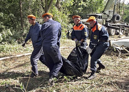 Cuatro trabajadores del Servicio de Emergencias acarrean una bolsa con restos del Tu-154 cerca de Rostov.