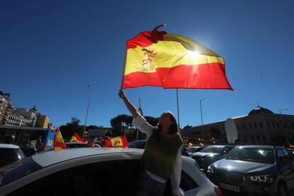 Una joven ondea una bandera de España en la plaza de Colón de Madrid.