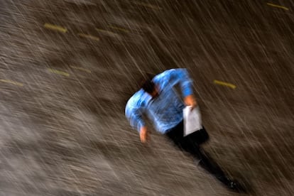 Un hombre camina bajo la lluvia por una c&eacute;ntrica calle de Mosc&uacute;, Rusia.