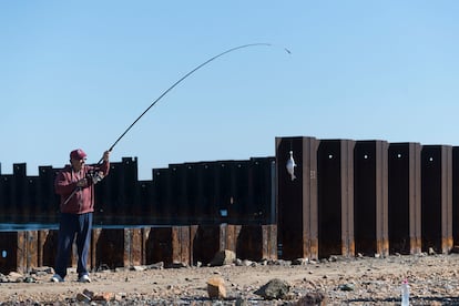 Un pescador entre los pilotes que conforman la estructura del puerto.