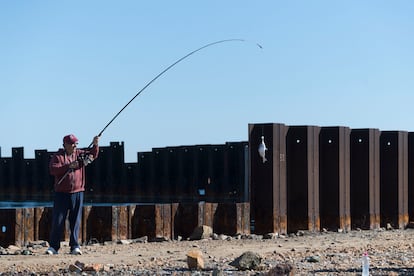 Un pescador entre los pilotes que conforman la estructura del puerto. 