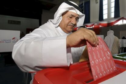 Un hombre deposita su voto en la primeras horas de la jornada electoral en Bahrein.