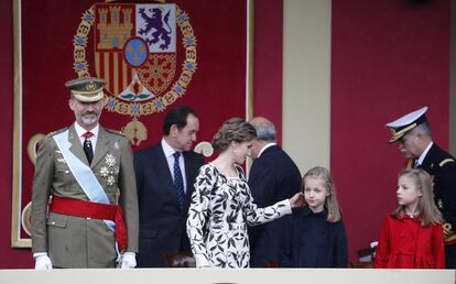 La Reina coloca el pelo a su hija Leonor en presencia de Sofía. Mientras el Rey atiende al desfile.