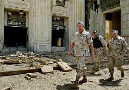 El general Tommy Franks pasea junto a las ruinas de un palacio de Sadam Husein el miércoles en Bagdad.