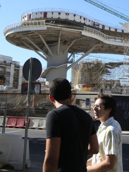 Dos vecinos de Sevilla pasan frente a las obras del Metrosol, proyecto conocido como 'las setas'.