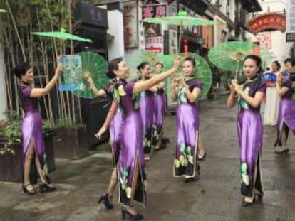 Jóvenes con sombrillas y trajes tradicionales en Hangzhou (China).