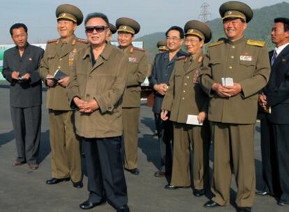 El líder supremo de Corea del Norte, Kim Jong-il, con su cuñado, , Jang Song Thaek (el primero a la izquierda), en una visita a una fábrica de fruta.