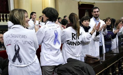 Los sanitarios se han sentado en los escaños y, una vez todos situados, se han puesto batas blancas y han sacado carteles con lazos negros en apoyo a la sanidad pública. 'Sanidad pública' o 'Sí se puede' han sido algunos de los lemas que han coreado durante una media hora.