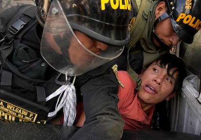 An anti-government protesters who traveled to the capital from across the country to march against Peruvian President Dina Boluarte, is detained and thrown on the back of police vehicle during clashes in Lima, Peru, Thursday, Jan. 19, 2023.