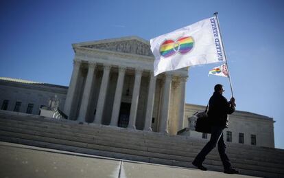 Homem posa com bandeira ante o Supremo em Washington.