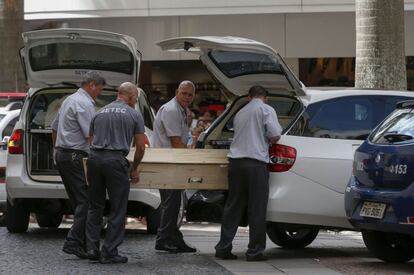 Los empleados trasladan el cuerpo de las víctimas mortales del tiroteo perpetuado en Campina.  