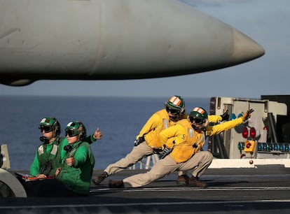 Operarios de vuelo preparan el lanzamiento de un F18 Super Hornet de la cubierta del portaaviones Eisenhower en la costa de Virginia.