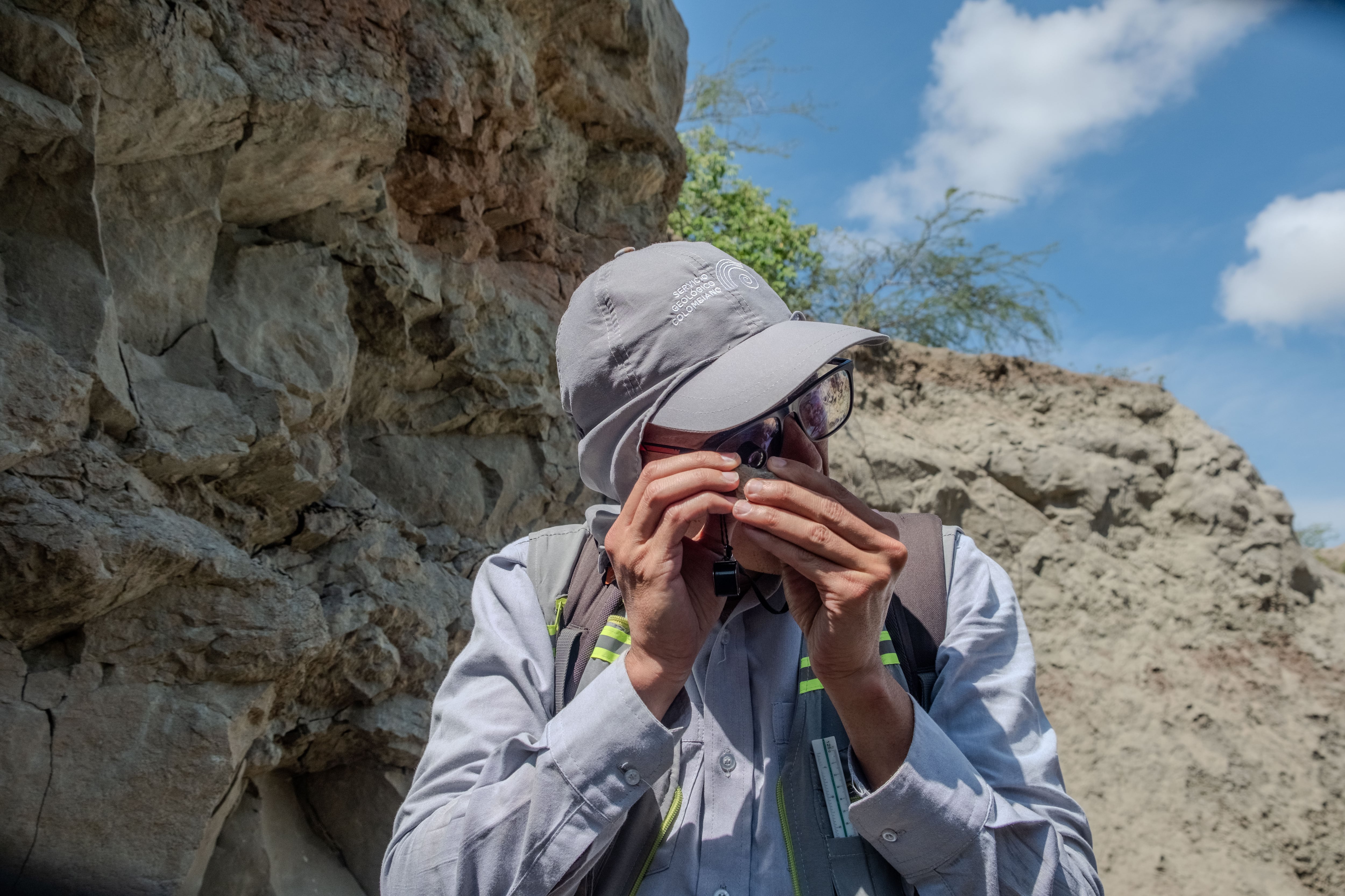 Luis Francisco Melo, del Servicio Geológico Colombiano, examina con lupa una roca para determinar su variedad, en el desierto de la Tatacoa.