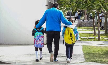 Un hombre camina con dos de sus hijas, afuera del colegio en Coahuila, al norte de México.