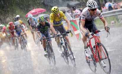 Froome (c) asciende bajo la lluvia junto a Mollema (d) y Quintana.