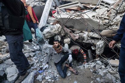 Varios palestinos buscan entre los escombros de un edificio colapsado en Rafah, este viernes. 