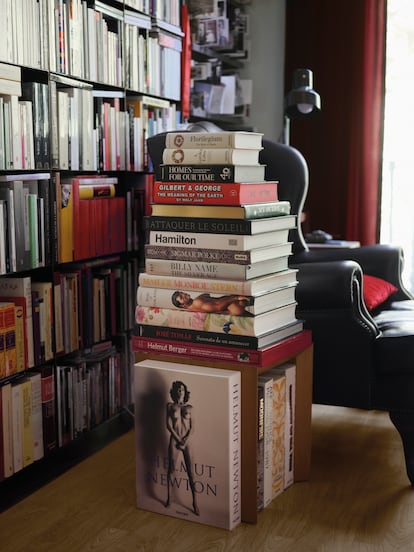 En un rincón de lectura del salón, junto a un sillón orejero de piel, una torre de libros coffee table de Taschen. 