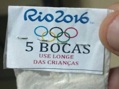 Envelope plástico de cocaína com o símbolo dos Jogos e a advertência.