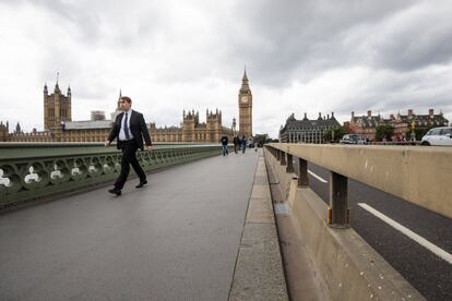 Un hombre cruza el puente de Westminster, donde se han instalado barreras de protección, el 6 de junio del 2017.