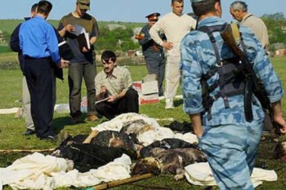 Oficiales de policía examinan los cadáveres de las víctimas del atentado que se produjo al este de Chechenia.