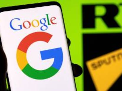 El logo de Google se ve en un smartphone delante del logo de RT y Sputnik.