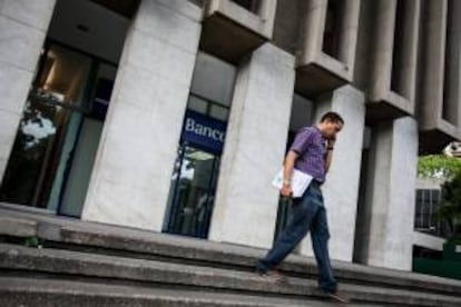 Un hombre camina frente a una entidad bancaria en Caracas (Venezuela). EFE/Archivo