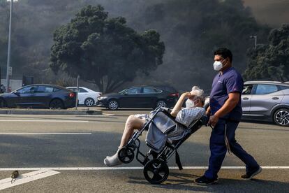 A man is evacuated in Pacific Palisades, California.